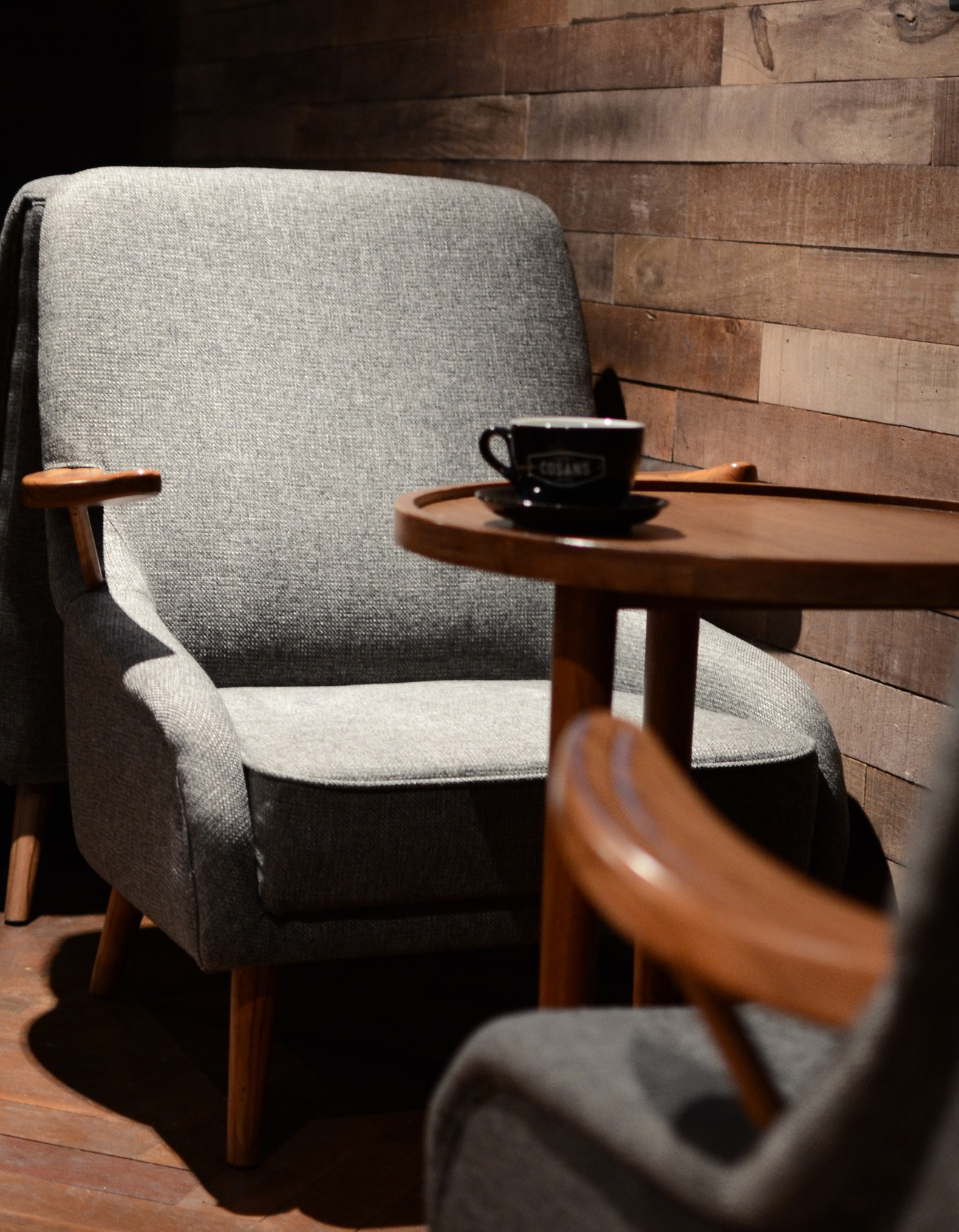A coup of coffee on a table with two chairs
